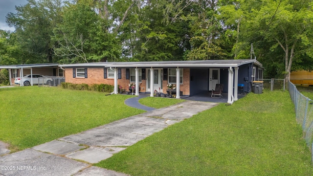 3165 Victoria Park Rd, Jacksonville, FL 32216 - single story home with fence, a front yard, an attached carport, brick siding, and driveway