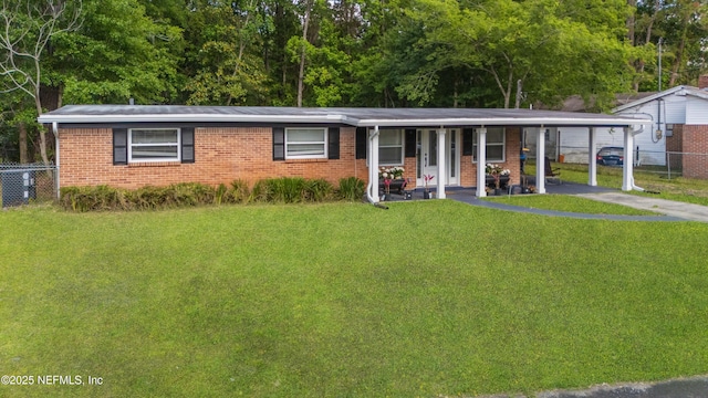 3165 Victoria Park Rd, Jacksonville, FL 32216 - ranch-style house with fence, a front lawn, aphalt driveway, brick siding, and a carport