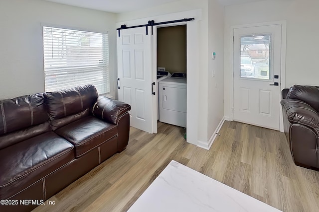 3165 Victoria Park Rd, Jacksonville, FL 32216 - living room featuring plenty of natural light, a barn door, light wood finished floors, and baseboards