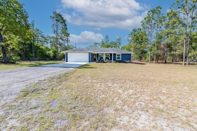 ranch-style home featuring an attached garage, a front lawn, fence, and driveway