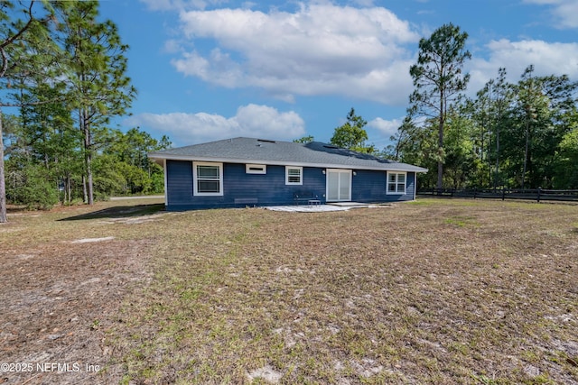 rear view of house featuring a lawn, a patio, and fence