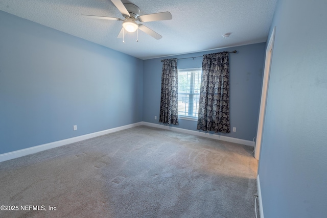 empty room featuring carpet floors, ceiling fan, baseboards, and a textured ceiling