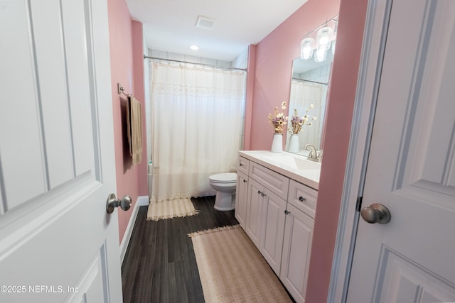 bathroom with visible vents, curtained shower, wood finished floors, vanity, and toilet