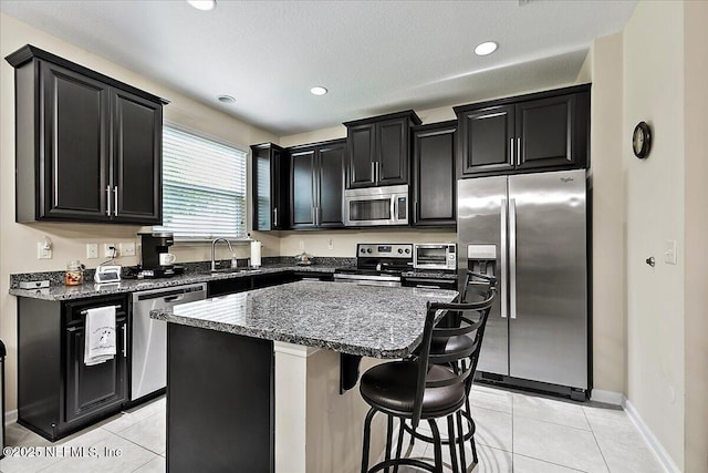 229 Adelanto Ave, Saint Augustine, FL 32092 - kitchen with appliances with stainless steel finishes, dark cabinetry, a sink, light tile patterned flooring, and recessed lighting