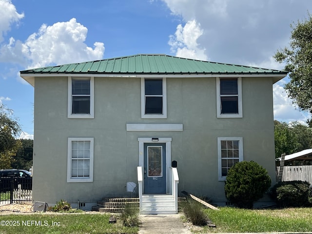 902 4th St N, Jacksonville Beach, FL 32250 - traditional-style home with stucco siding, metal roof, and fence