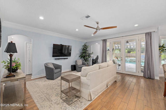 14526 Starbuck Springs Way, Jacksonville, FL 32258 - living area featuring arched walkways, french doors, light wood-style flooring, a ceiling fan, and ornamental molding
