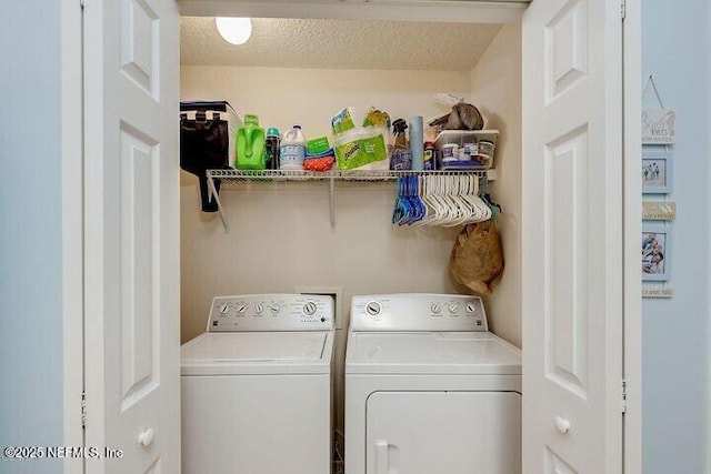 laundry area featuring a textured ceiling, laundry area, and washer and clothes dryer