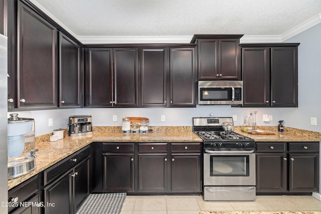 221 Saint Kitts Loop, Saint Augustine, FL 32092 - kitchen featuring appliances with stainless steel finishes, ornamental molding, light tile patterned floors, light stone countertops, and a textured ceiling