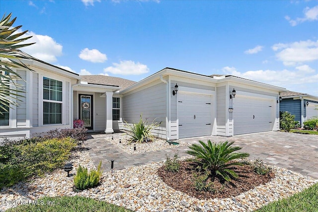 single story home featuring an attached garage and decorative driveway