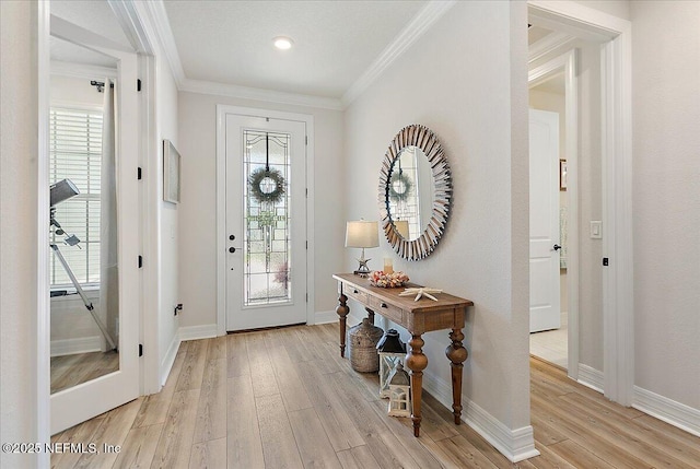 foyer with crown molding, baseboards, and light wood-type flooring