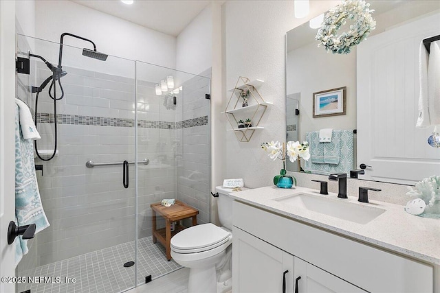 bathroom with vanity, a shower stall, and toilet