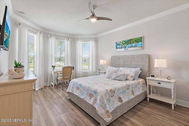 bedroom featuring crown molding, baseboards, ceiling fan, and light wood-type flooring