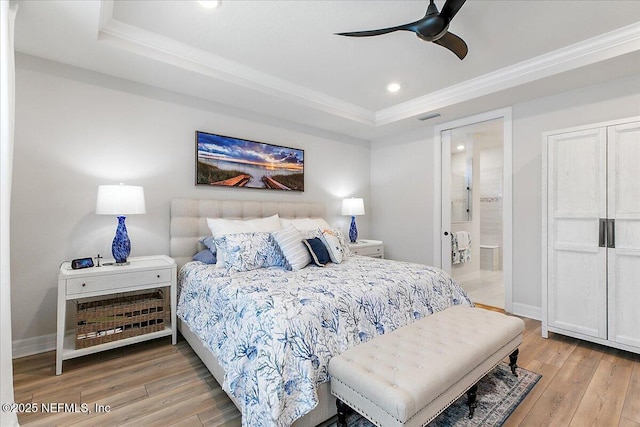 bedroom with visible vents, a raised ceiling, and light wood-style floors
