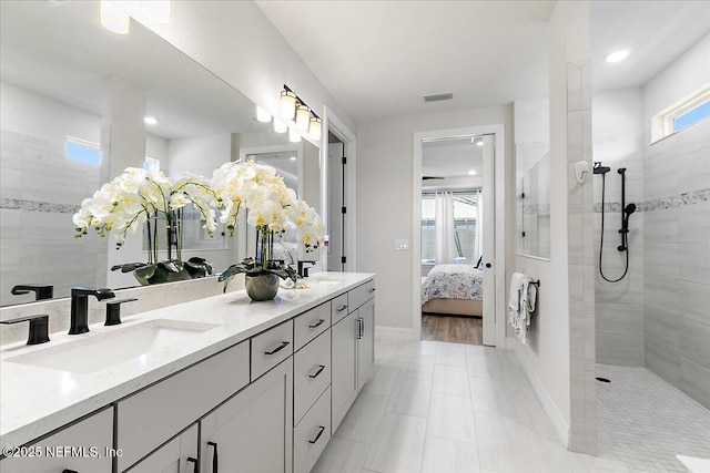 ensuite bathroom with double vanity, visible vents, a sink, a walk in shower, and ensuite bath