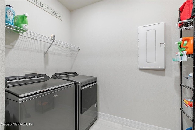 clothes washing area with laundry area, washing machine and dryer, and baseboards