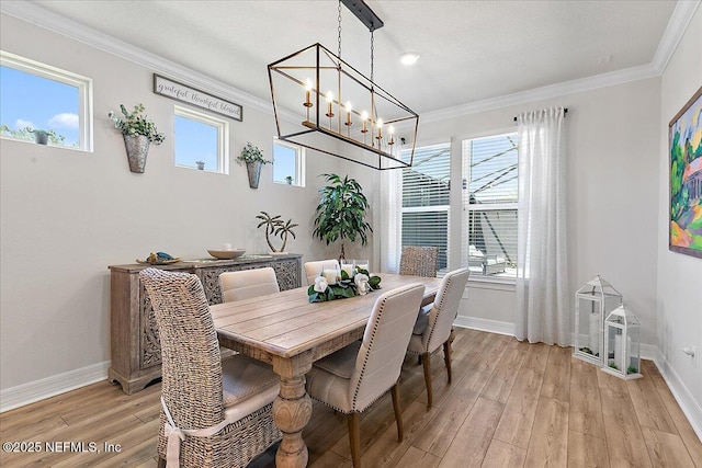 dining area with crown molding, baseboards, and a notable chandelier