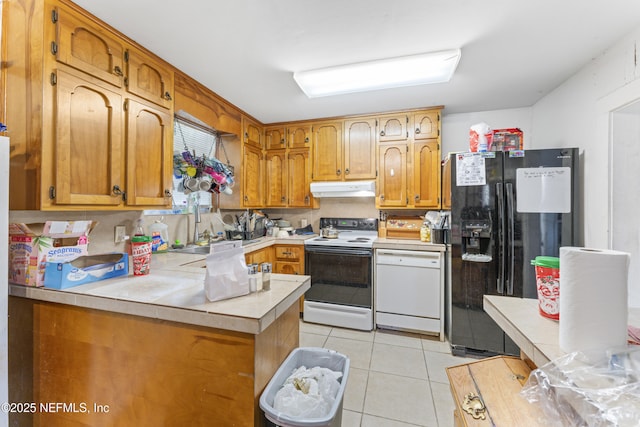 37885 Kings Ferry Rd, Hilliard, FL 32046 - kitchen featuring a peninsula, white appliances, under cabinet range hood, light countertops, and light tile patterned floors