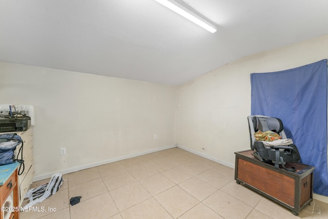 37885 Kings Ferry Rd, Hilliard, FL 32046 - empty room with light tile patterned floors, vaulted ceiling, and baseboards