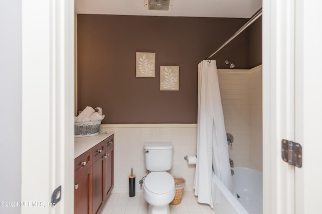 bathroom with toilet, tile walls, vanity, tile patterned flooring, and wainscoting