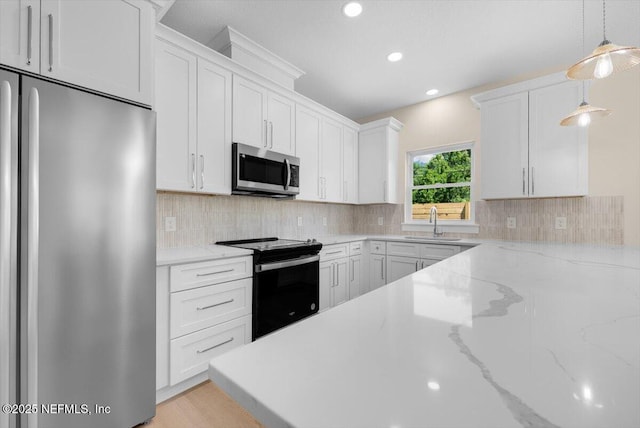 kitchen with decorative backsplash, decorative light fixtures, a sink, stainless steel appliances, and white cabinetry