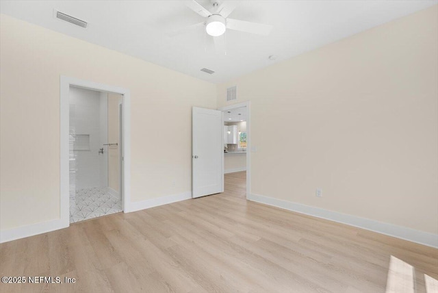 unfurnished bedroom featuring connected bathroom, baseboards, visible vents, and light wood-style flooring