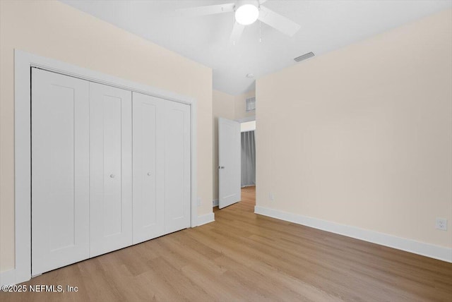 unfurnished bedroom featuring visible vents, a closet, wood finished floors, baseboards, and a ceiling fan
