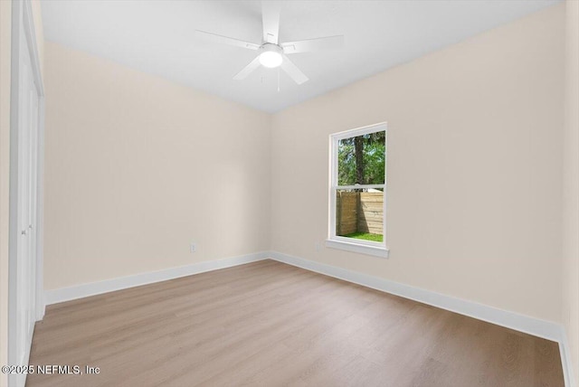 spare room featuring a ceiling fan, baseboards, and wood finished floors