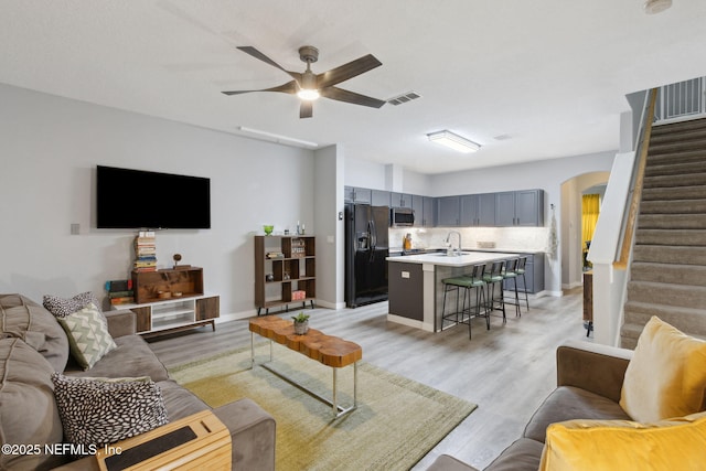 625 Oakleaf Plantation Pkwy Unit 1115, Orange Park, FL 32065 - living area with a ceiling fan, light wood-type flooring, visible vents, arched walkways, and stairs