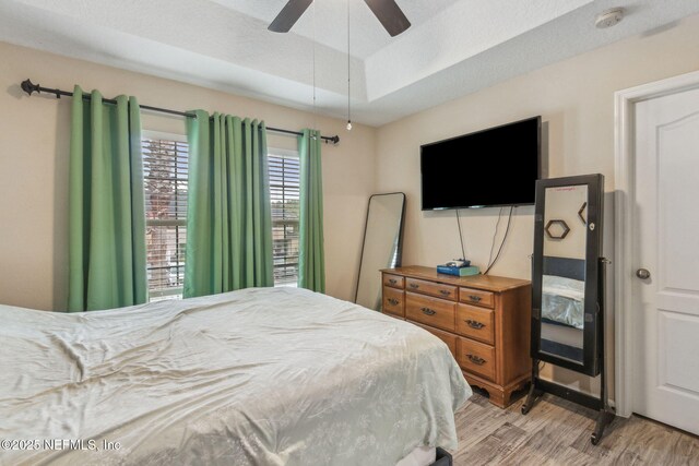 625 Oakleaf Plantation Pkwy Unit 1115, Orange Park, FL 32065 - bedroom featuring a ceiling fan, a raised ceiling, and light wood-type flooring
