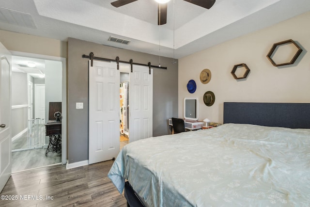625 Oakleaf Plantation Pkwy Unit 1115, Orange Park, FL 32065 - bedroom with a barn door, baseboards, visible vents, and wood finished floors