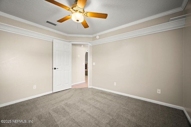 carpeted spare room featuring baseboards, ornamental molding, visible vents, ceiling fan, and arched walkways