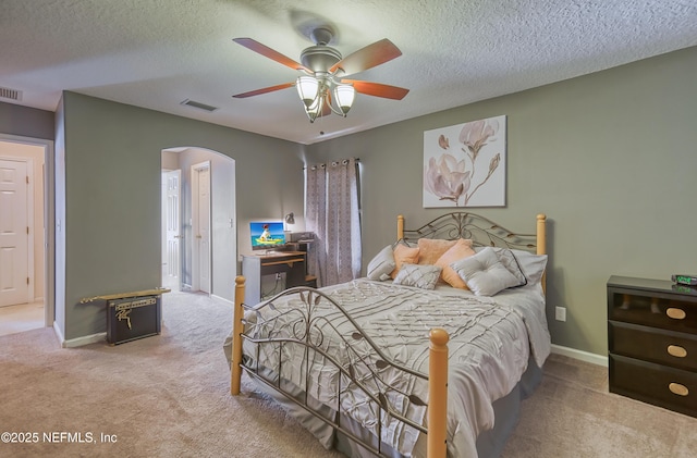 bedroom featuring carpet flooring, visible vents, and arched walkways