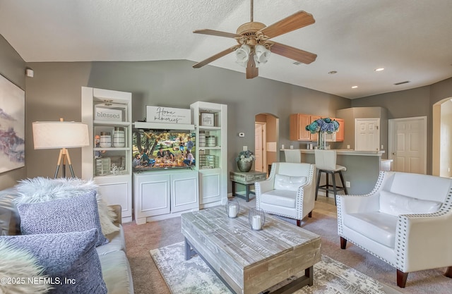 living room featuring recessed lighting, vaulted ceiling, light carpet, arched walkways, and a ceiling fan