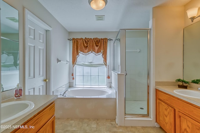bathroom featuring a shower stall, two vanities, and a sink