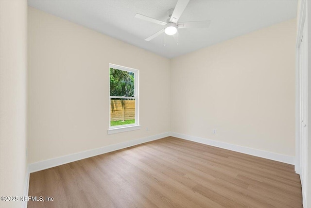 empty room featuring a ceiling fan, wood finished floors, and baseboards