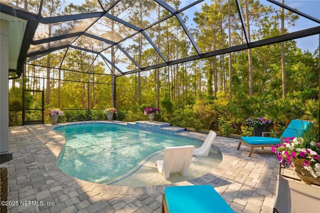 swimming pool featuring a patio and glass enclosure
