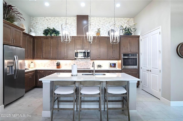 kitchen featuring appliances with stainless steel finishes, a chandelier, a sink, light marble finish floors, and recessed lighting