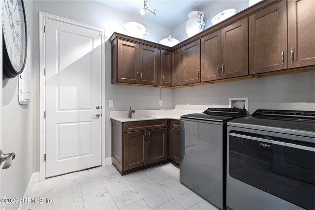 laundry room featuring light marble finish flooring, cabinet space, washer and clothes dryer, and baseboards