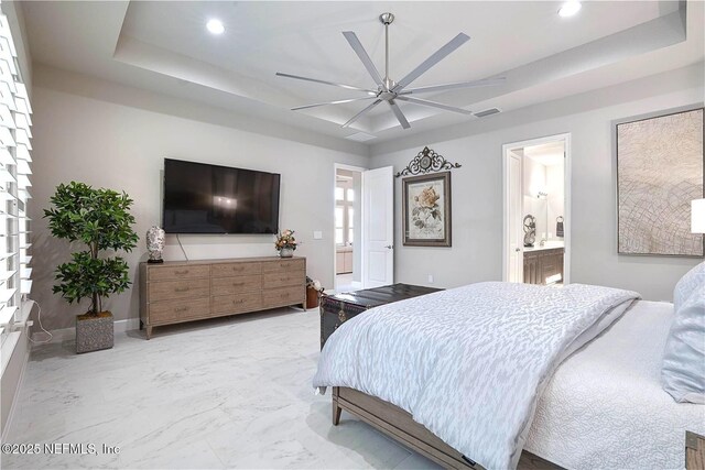 bedroom with a tray ceiling, recessed lighting, ensuite bathroom, a ceiling fan, and marble finish floors