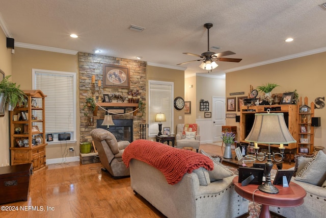 living room featuring crown molding, a textured ceiling, a ceiling fan, and wood finished floors