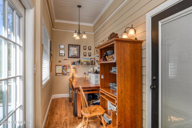 office area featuring crown molding, baseboards, a healthy amount of sunlight, and wood finished floors