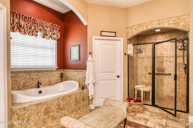 full bath with a stall shower and a garden tub