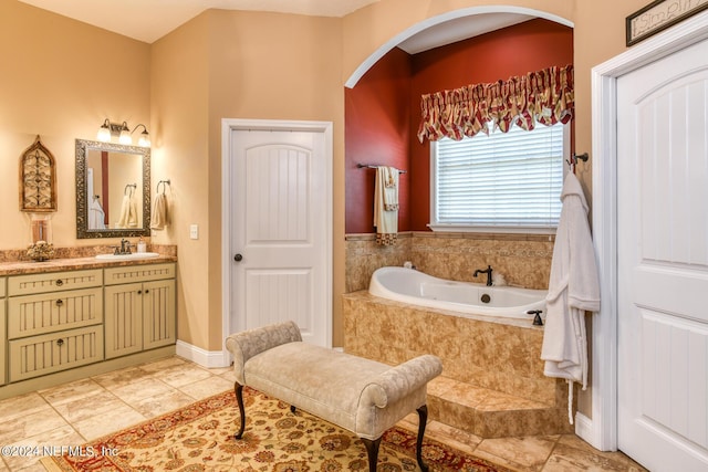 full bathroom featuring vanity, tile patterned flooring, and tiled bath