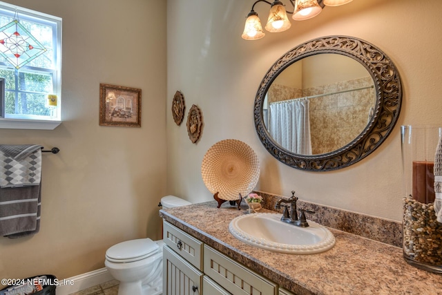 bathroom featuring toilet, a chandelier, curtained shower, and vanity