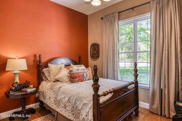 bedroom featuring baseboards and wood finished floors