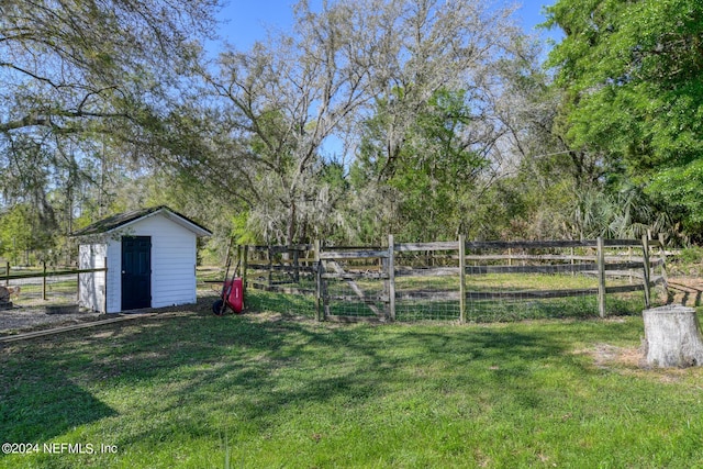 view of yard with a storage shed, an outbuilding, and fence