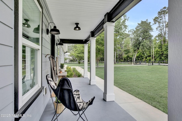 view of patio / terrace with a porch and view of wooded area