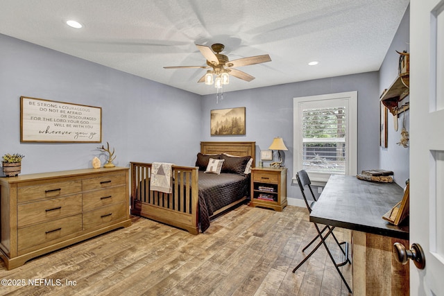 bedroom featuring light wood finished floors, a textured ceiling, a ceiling fan, recessed lighting, and baseboards