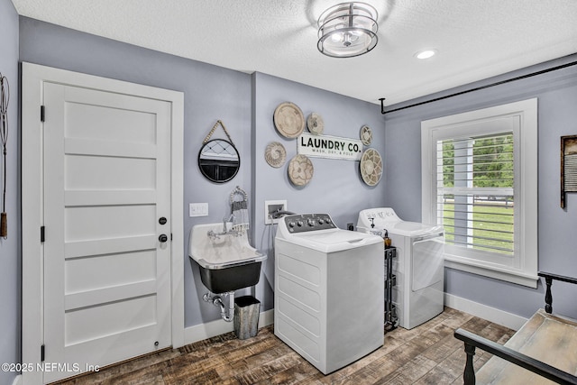 laundry area with washer and clothes dryer, baseboards, dark wood finished floors, and a textured ceiling