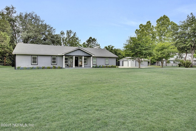 ranch-style house featuring a porch, an outbuilding, and a garage